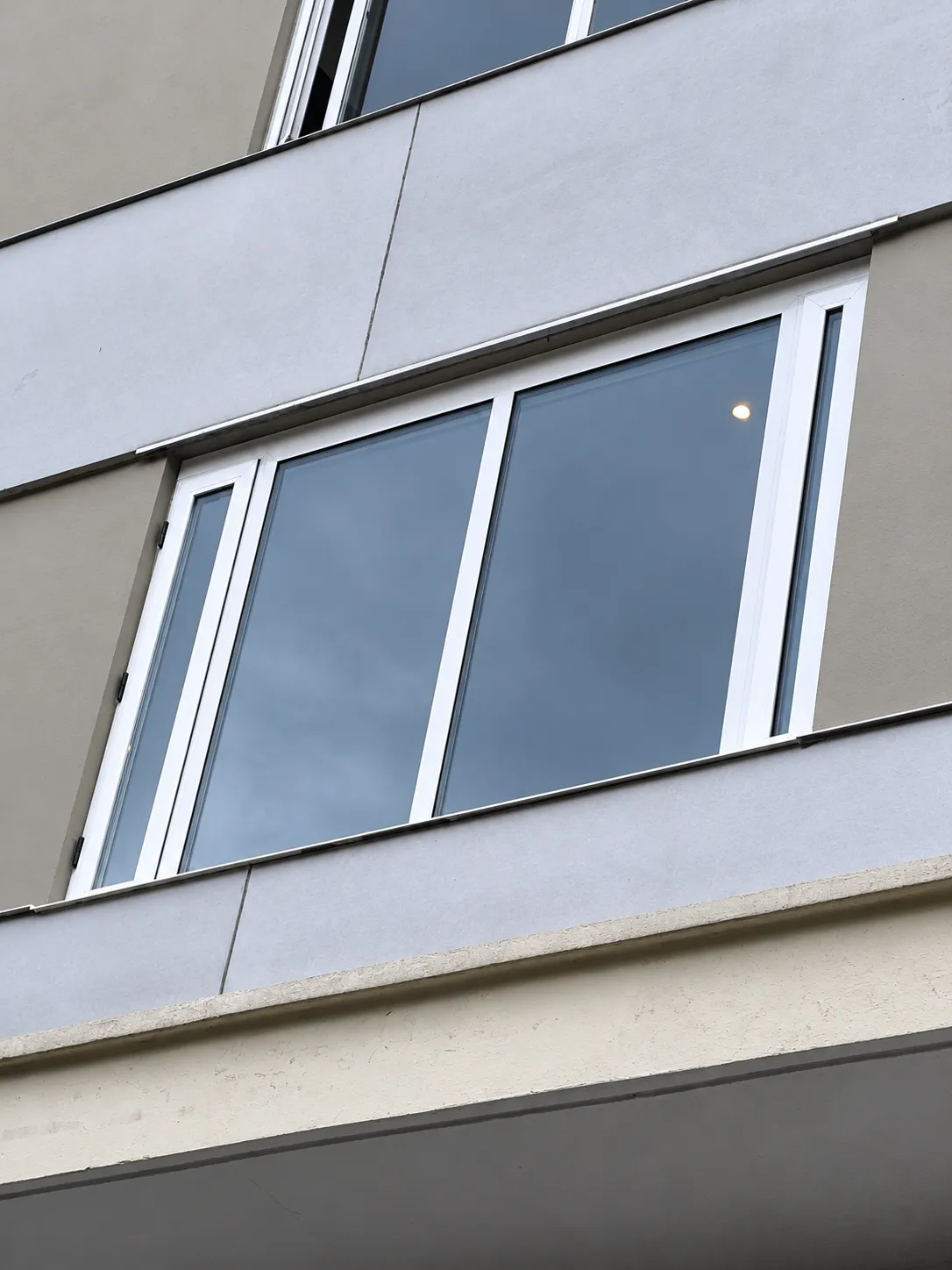 Ventana en perfil blanco con vidrios amplios en la fachada de un edificio