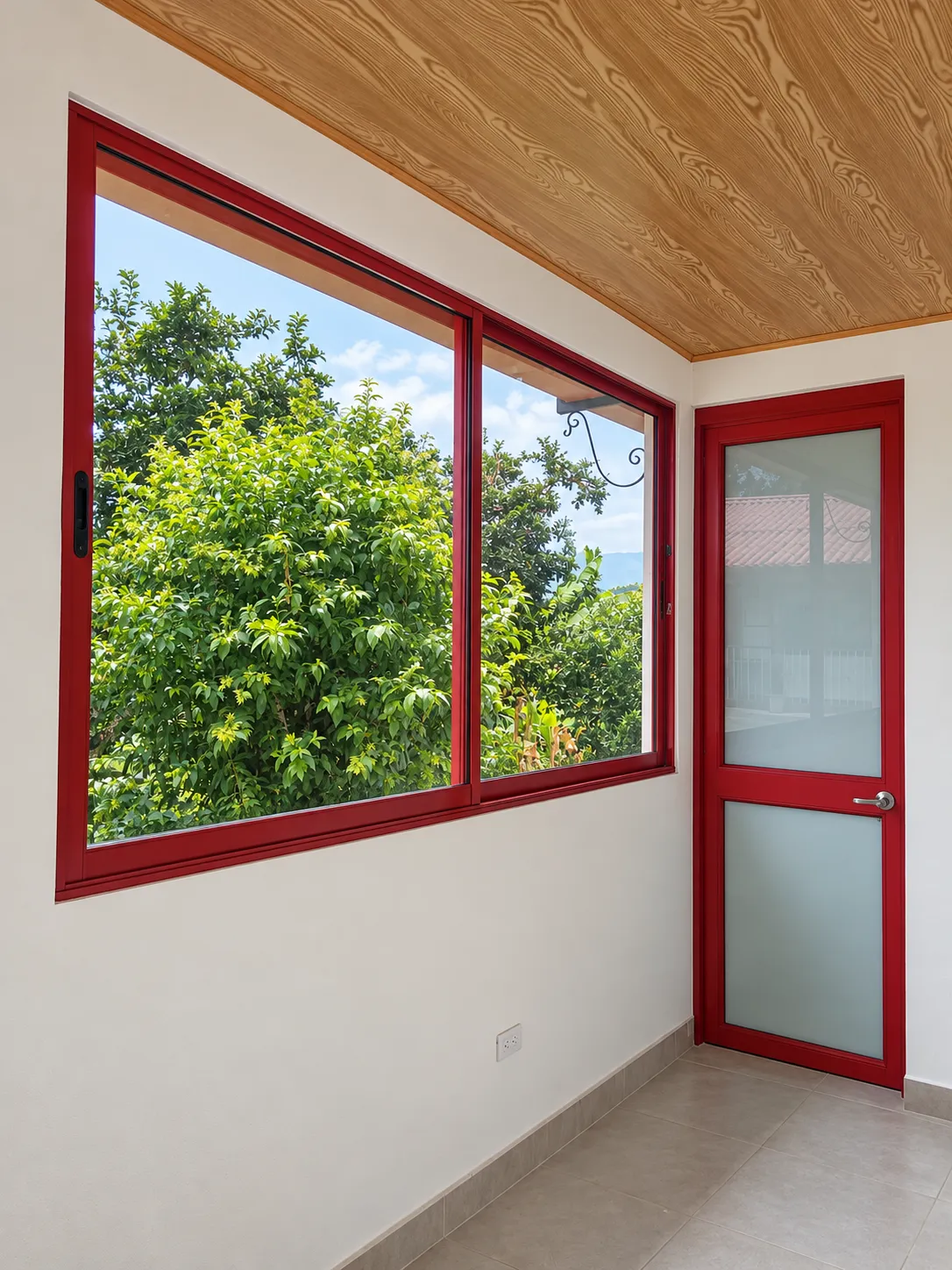 Ventana corrediza de dos hojas y puerta con vidrio esmerilado, ambas en aluminio rojo